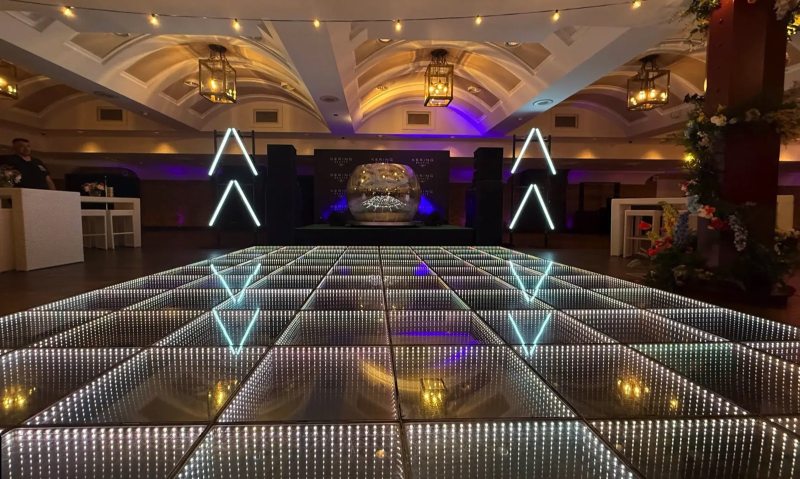 3D infinity mirror LED dance floor installed in a vaulted ballroom with lantern chandeliers