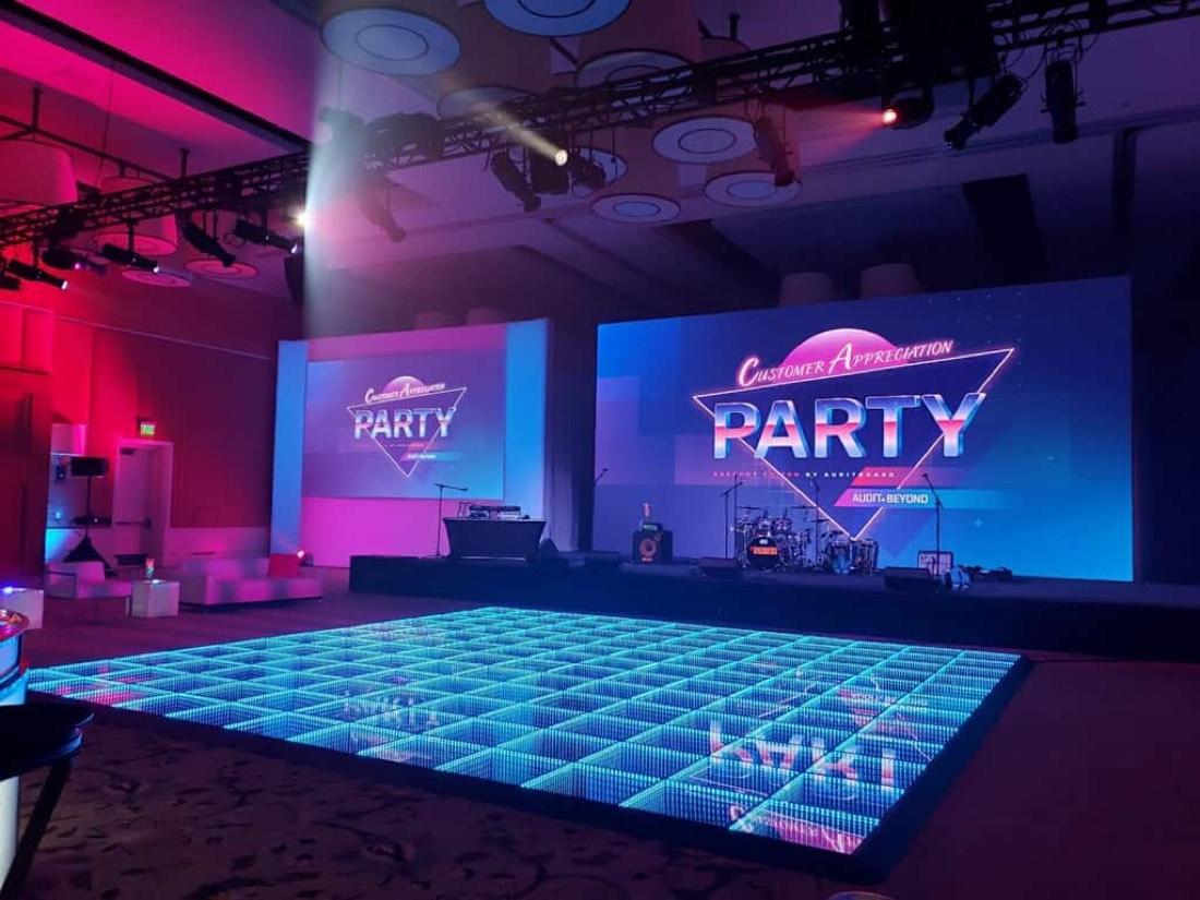 Blue infinity LED dance floor at a corporate customer appreciation party with stage and screens