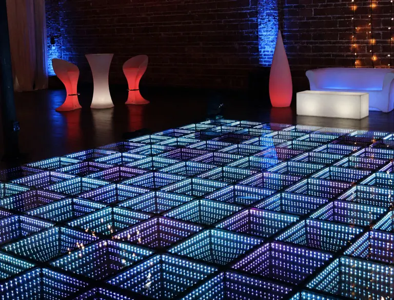 Blue infinity LED dance floor surrounded by illuminated lounge furniture