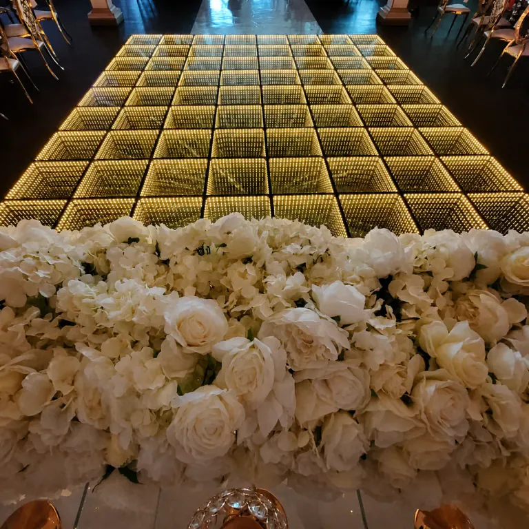 Warm gold infinity LED floor framed by white flowers