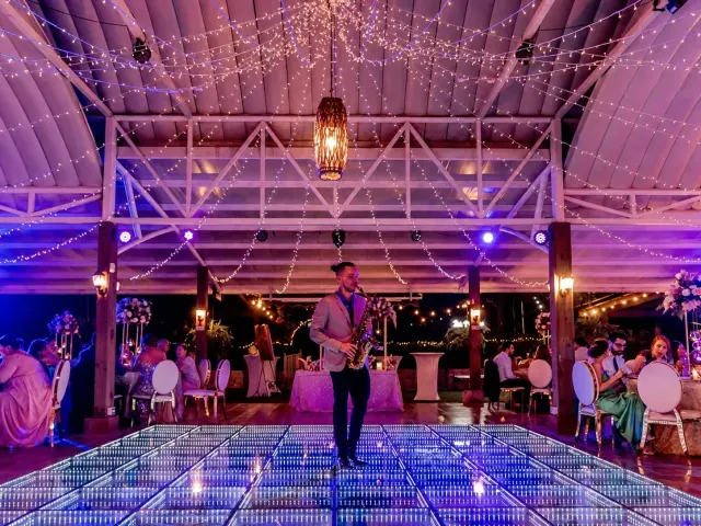 Saxophone player performing beside an infinity LED dance floor