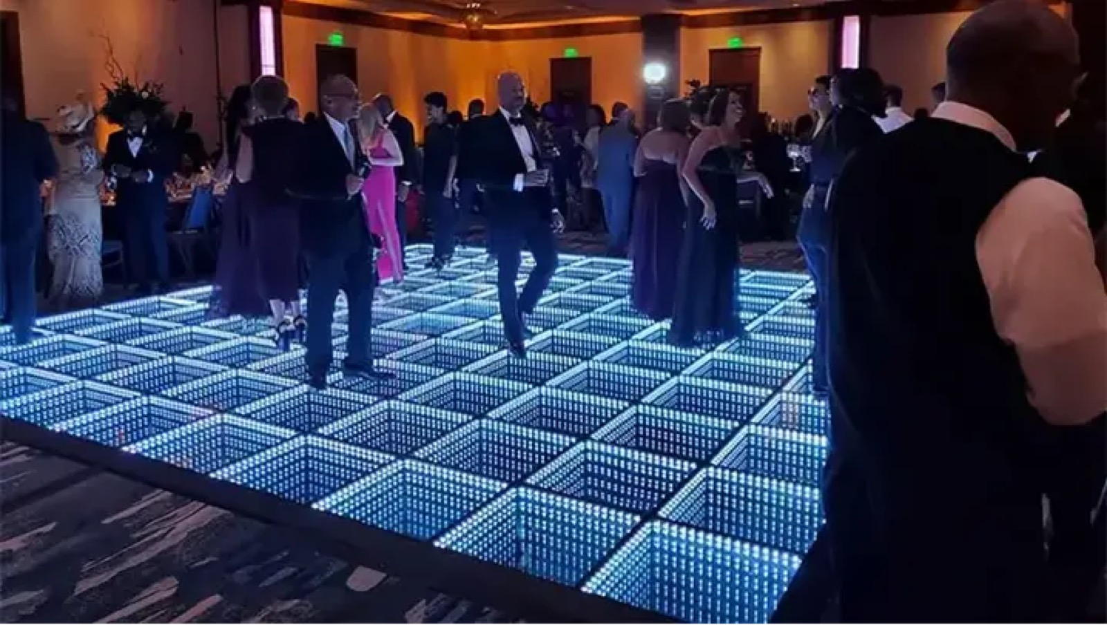 Guests dancing on a white infinity LED dance floor during a formal evening reception