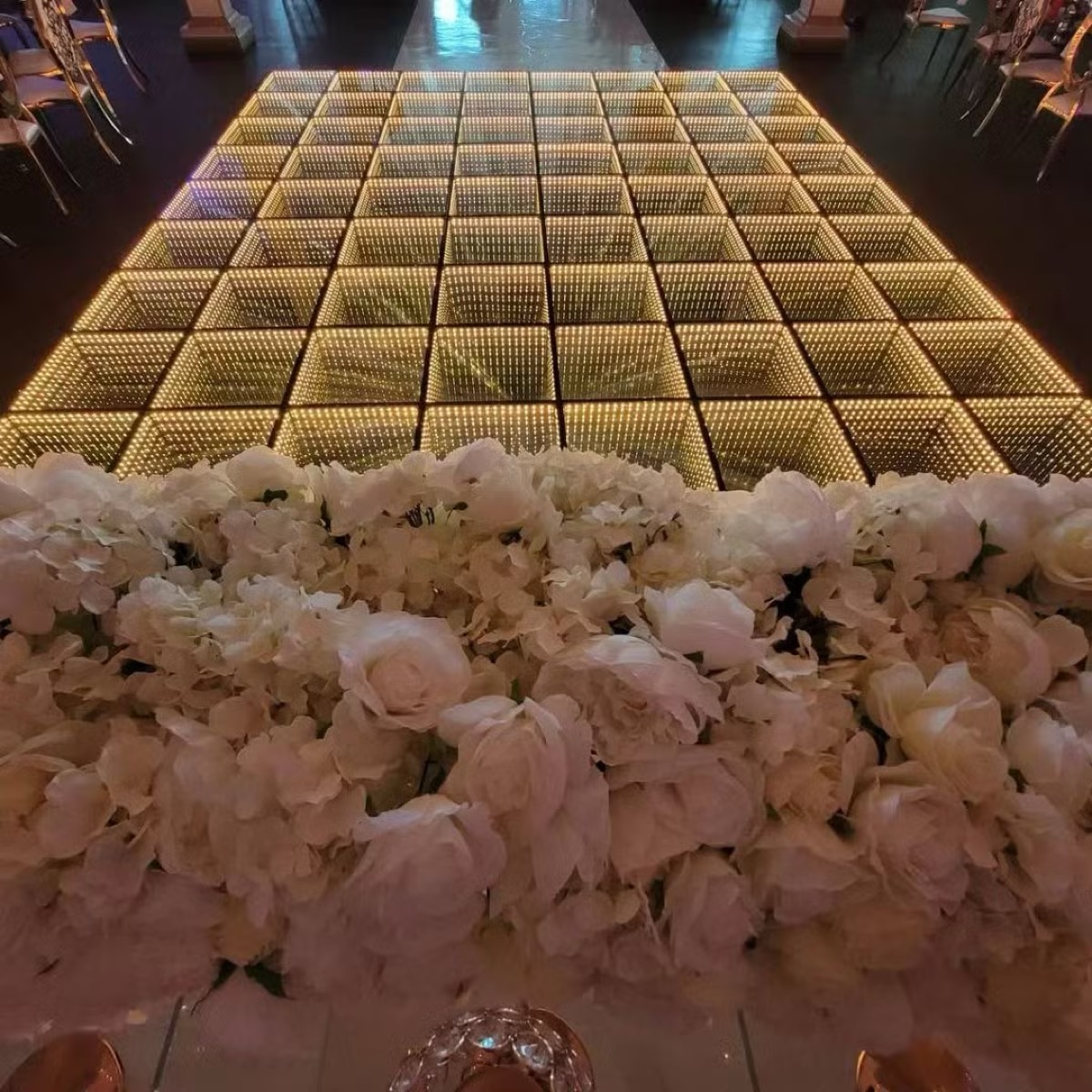 Infinity LED dance floor glowing in warm golden mode at an elegant event