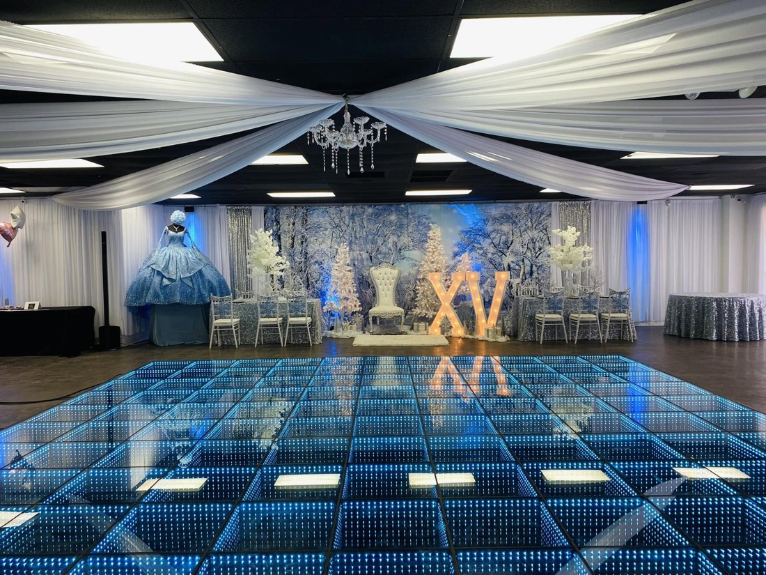 Blue infinity LED dance floor at a winter wonderland quinceañera with white drapery
